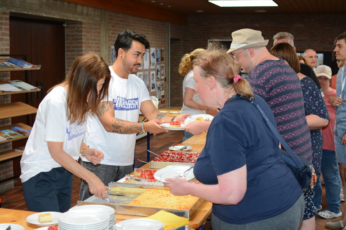 Kuchenausgabe mit Mitarbeitenden der WICM