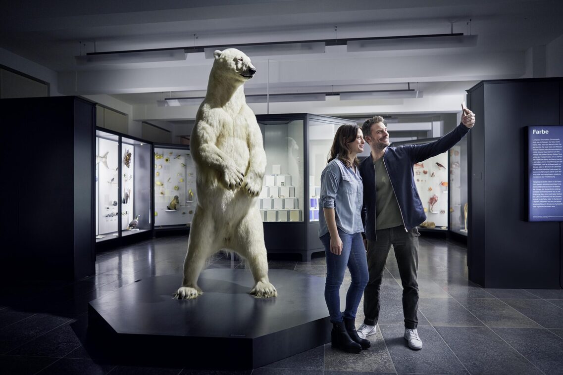 Eine Frau und ein Mann machen ein Selfie im Museum Wiesbaden vor dem Eisbär